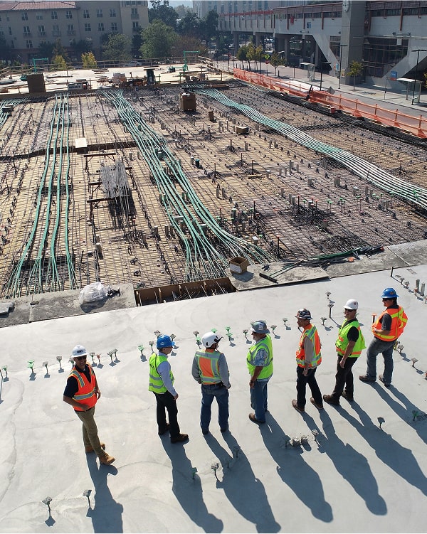 Stavební tým kontroluje rozestavěný projekt na staveništi